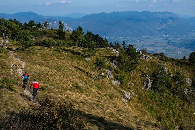 two men biking trans slovenia trail in beautiful nature