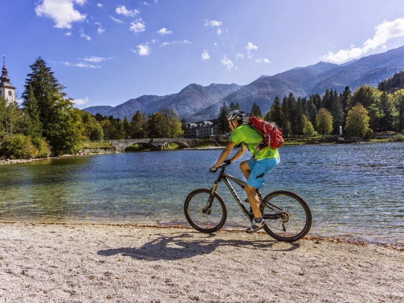 Biker on the shore of Lake Bohinj during a mountain bike tour in Slovenia