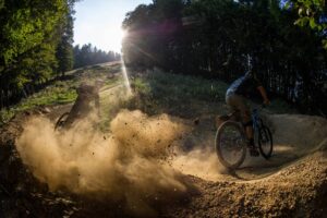 Mountain biker riding a dusty bike park trail on the Trans Slovenia 04 MTB tour