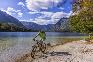 Mountain biker riding beside Lake Bohinj on the Trans Slovenia 02 MTB tour