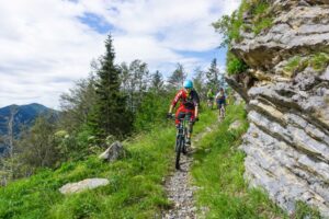 Mountain biker riding a narrow alpine trail at Soriška Planina on the Trans Slovenia 02 MTB tour