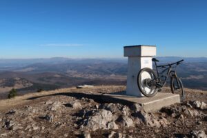 Mountain bike beside the summit marker on the Mt Slavnik MTB route in Slovenia