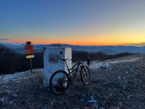 Mountain bike beside the summit marker on Mt Vremščica during a biking tour in Slovenia