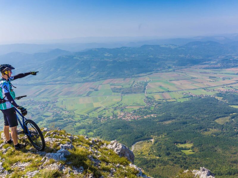 Biker overlooking the Vipava Valley on a mountain bike tour in Slovenia