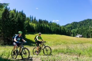 Mountain bikers cycling across Pokljuka Plateau on the Trans Slovenia 02 MTB tour