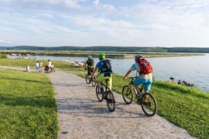Mountain bikers cycling beside the Sečovlje Salt Pans on a biking tour in Slovenia