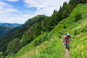 Mountain bikers exploring off the beaten track MTB route in Slovenia at Soriška Planina