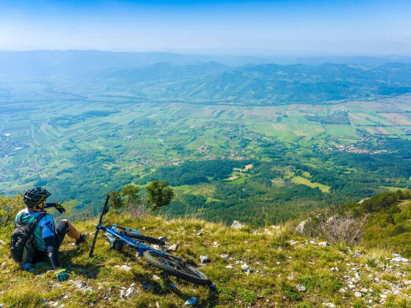 Mountain biker resting above the Vipava Valley on the Trans Slovenia 02 MTB route