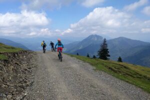 Mountain bikers riding a scenic gravel road through the mountains on the Trans Slovenia 04 biking tour