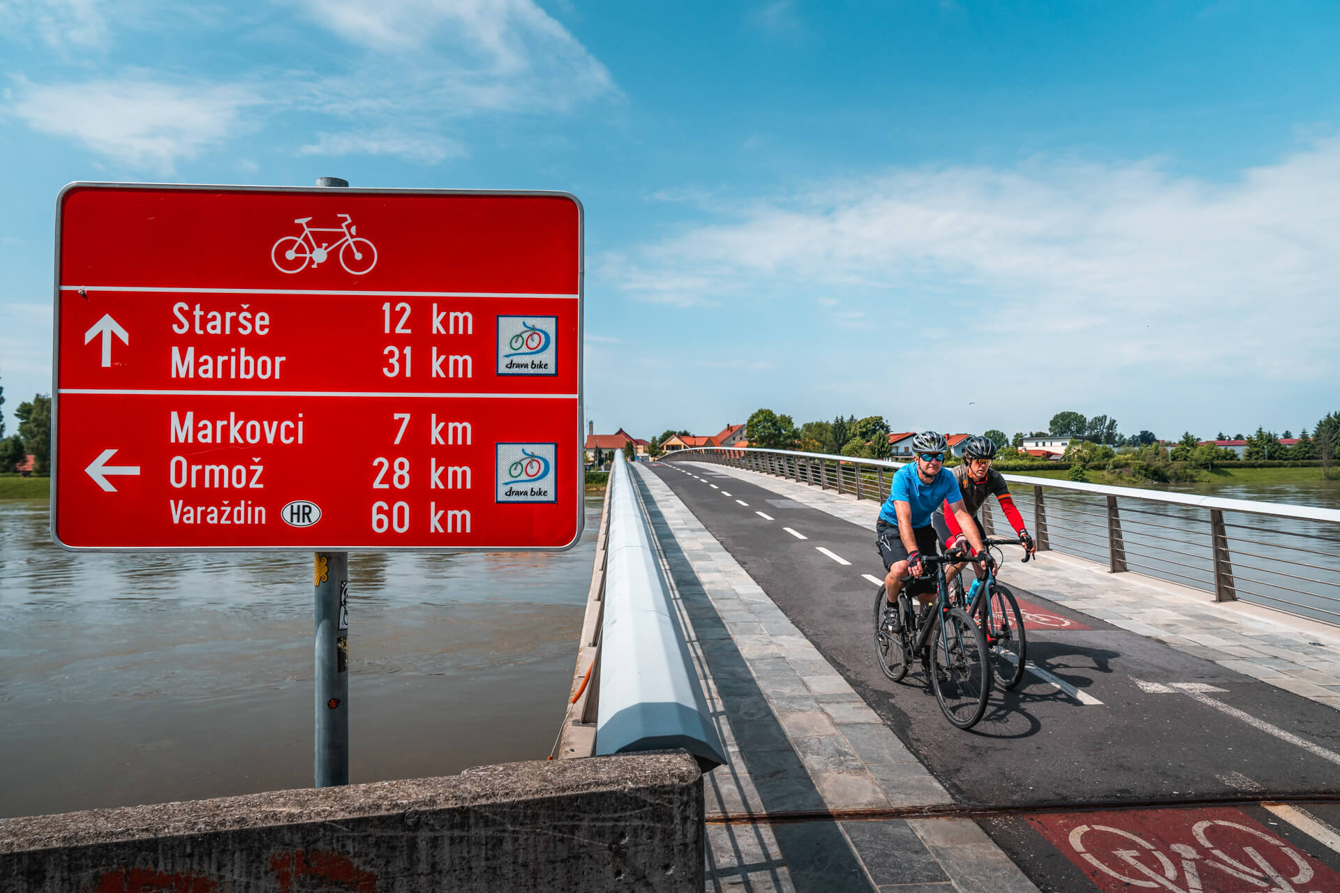 Cyclist crossing bridge across Drava