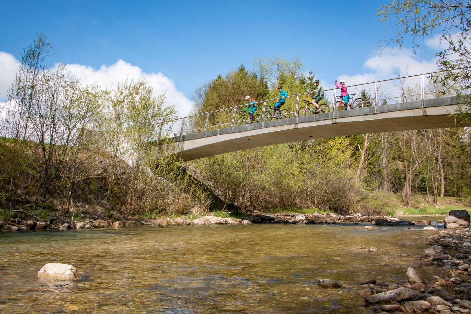 Cylists crossing the bridge in Slovenia on autumn bike tour