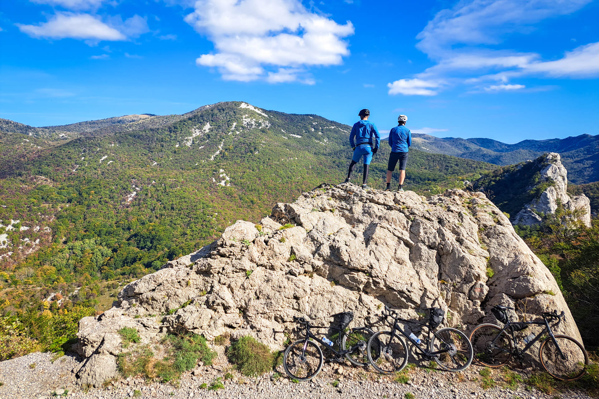 Two cyclists on gravel bikes enjoy the views of the forests in Croatia.