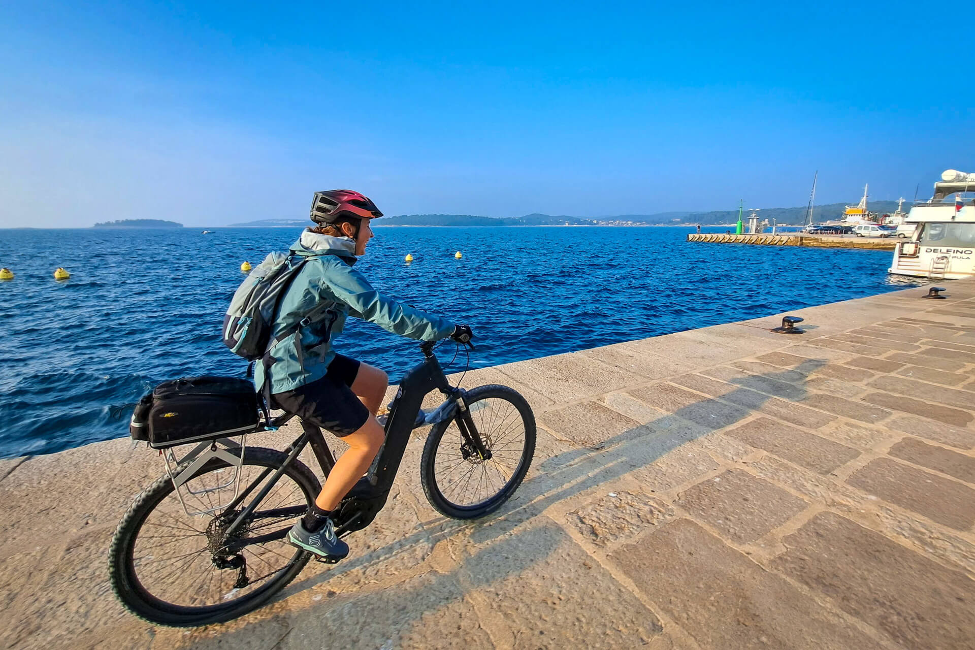 A female cyclists on an e-bike on Adriatic coast, Croatia.