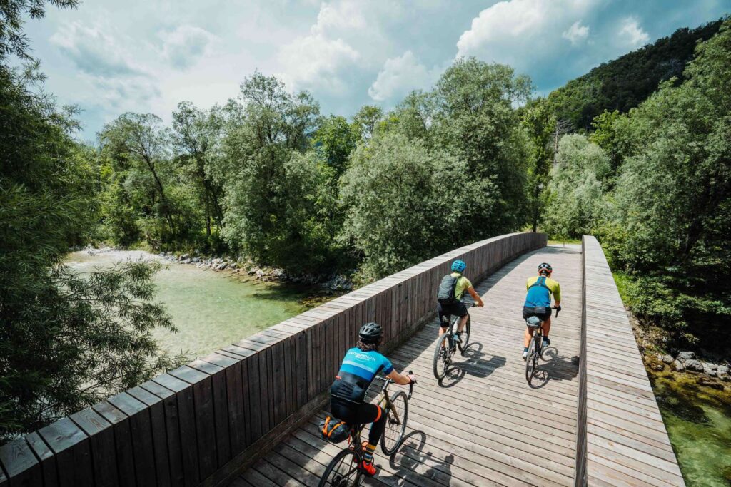Three cyclists are crossing the bridge across Sava river