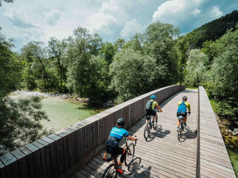 Three cyclists are crossing the bridge across Sava river