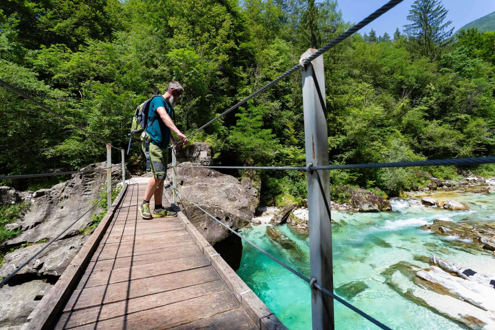 Hiker standing on the bridge across Soča River