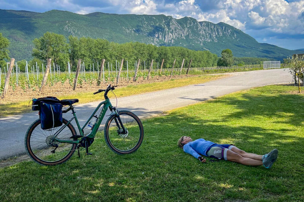 A cyclist resting on the side of the road in Vipava Valley.